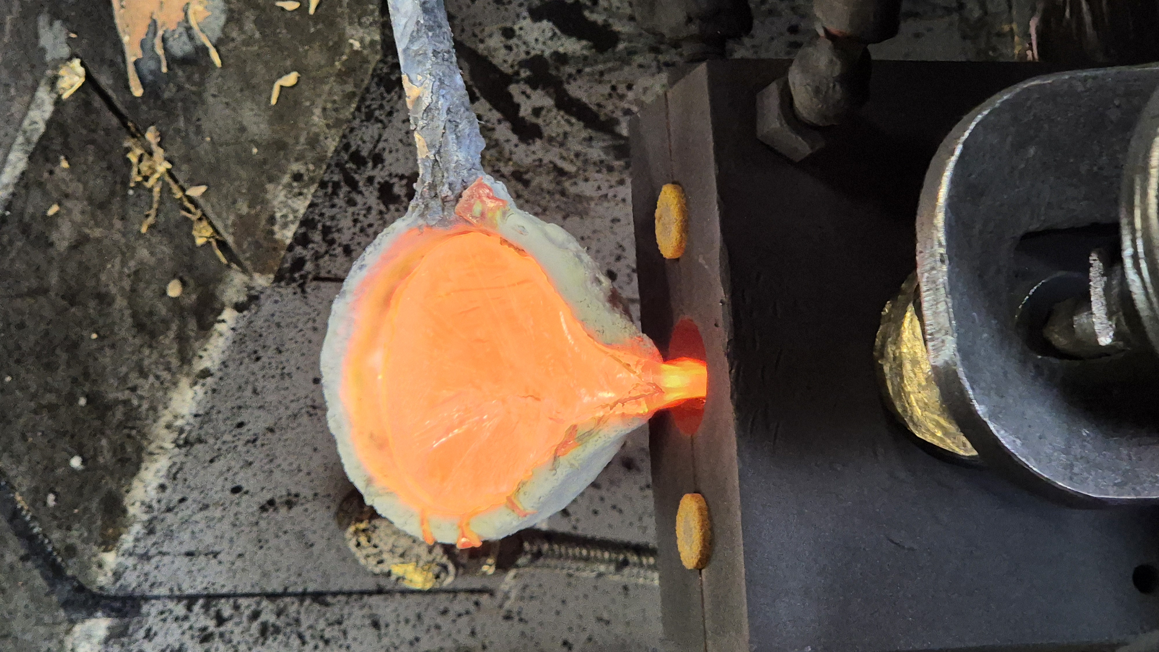 Molten brass being poured into a mold during casting