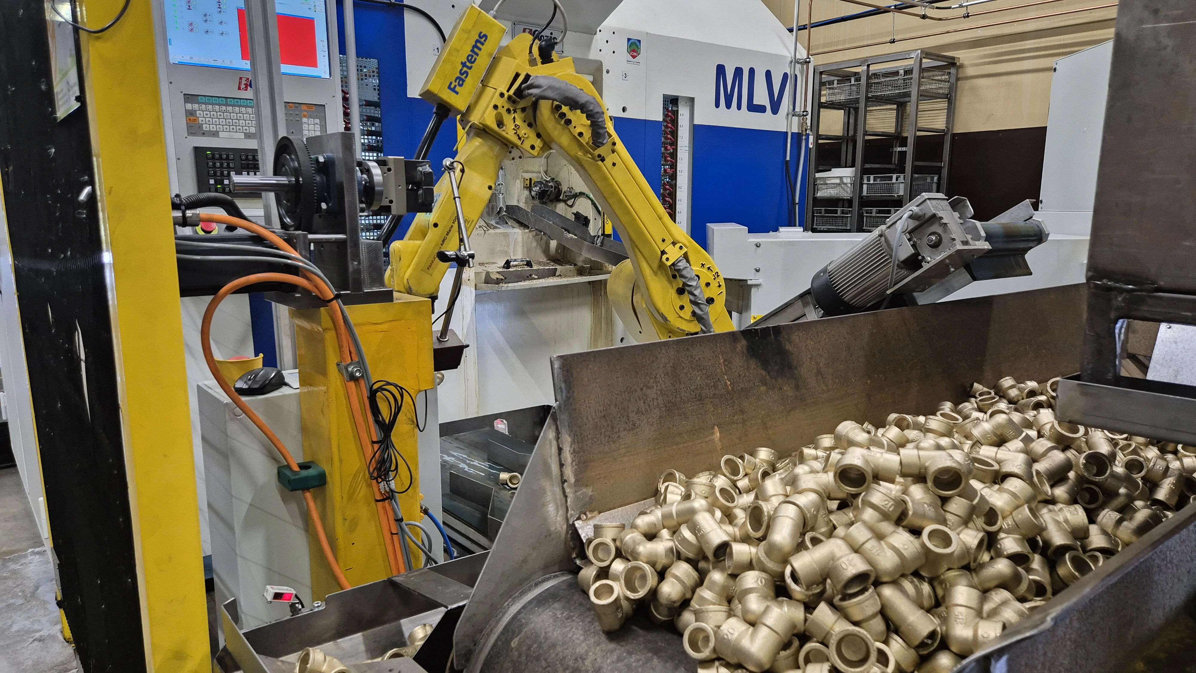A machining process with a robotic arm and finished brass parts